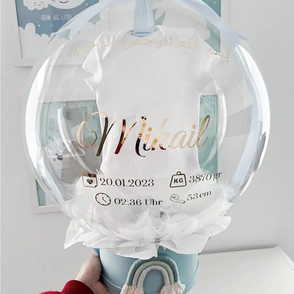 Klarer Ballon mit einem weißen Babylätzchen (Baby-Onesie) mit goldfolierter Namensangabe und Geburtsdetails, mit individuellem Baby-Party-Ballonaufkleber für 36-Zoll-Bobo-Ballons.
