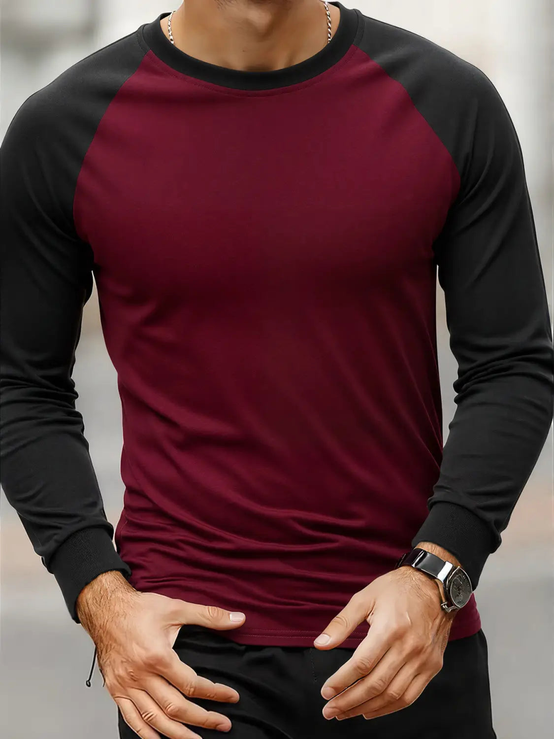 Herren-Raglanshirt mit langem Ärmel in Bordeauxrot und Schwarz mit gerippten Bündchen und Ausschnitt, für den lässigen Einsatz entworfen.