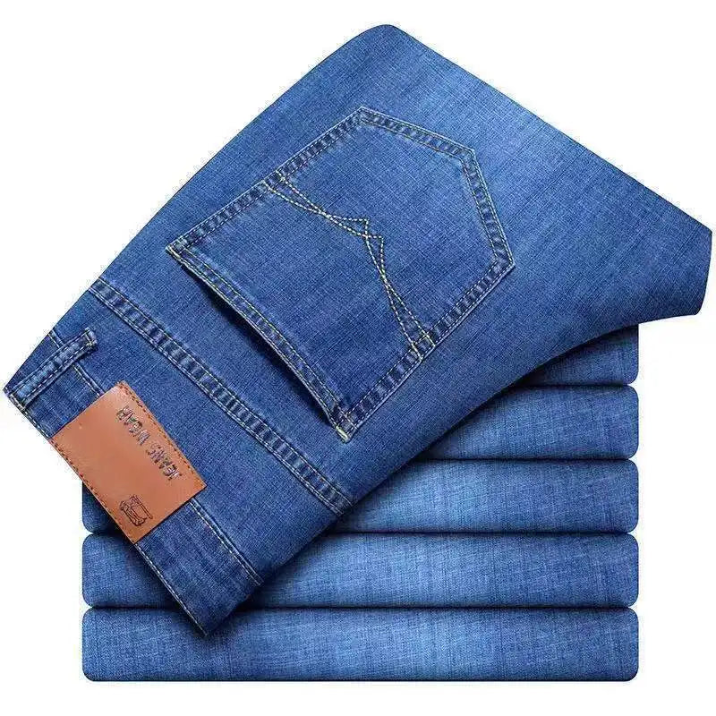 Jeans stretch en denim à jambe droite pour homme en bleu, avec une étiquette de marque en cuir brun sur la ceinture.