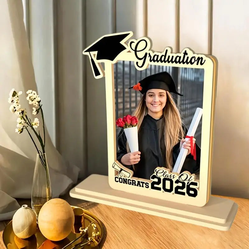 Beige wooden graduation photo frame with black cutout accents featuring a mortarboard design, graduation text at the top, and class of 2026 at the bottom for commemorating the class of 2026.