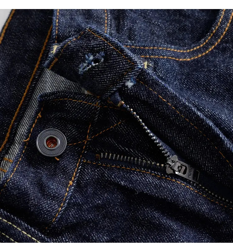 Heavyweight red selvedge denim jeans in dark blue with contrasting orange stitching and a metallic button.