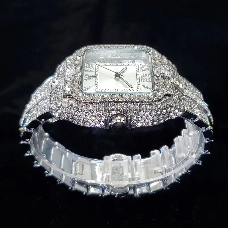 A dazzling square-faced iced out diamond watch for men featuring a silver-toned, diamond-encrusted case and bracelet with blue accents.