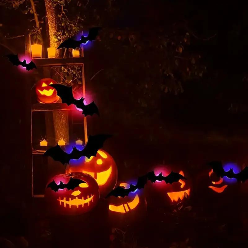 lámpara de noche LED estereoscópica con forma de murciélago, con LED naranjas en estado luminoso, que incluye caras talladas de jack-o'-lantern de material PET, con decoraciones de murciélago negras.