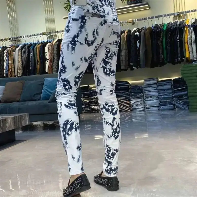 White denim jeans with a bold black floral and star pattern featuring a slim fit design for men.