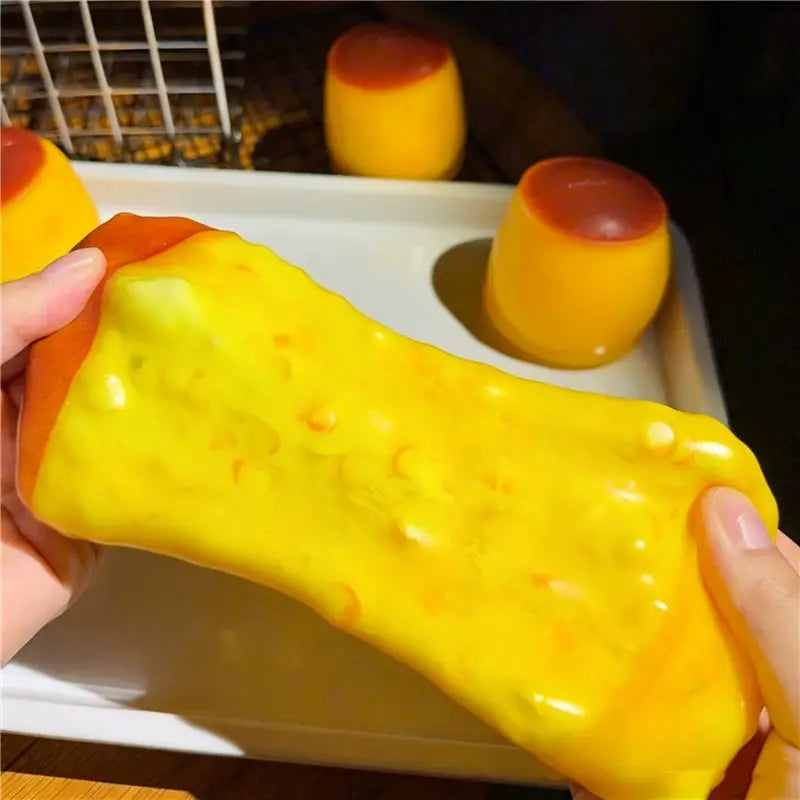 Un jouet sensoriel de type balle anti-stress en forme d’arachide jaune vif, extensible, avec des marbrures orange et une finition brillante.