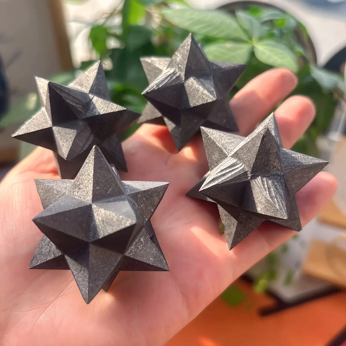 cristaux de merkaba en shungite noirs géométriques en forme d’étoile, avec un éclat métallique et des facettes superposées, pour une décoration intérieure élégante et un style décoratif.