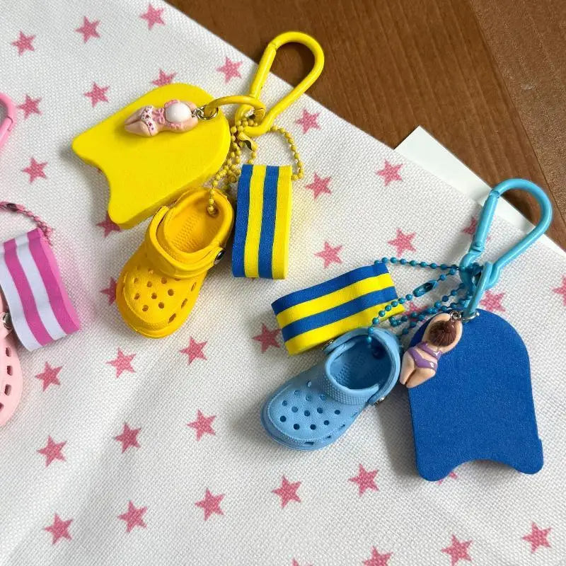 summer beach clog keychain bag charm featuring yellow and blue miniature croc-style shoes with matching swim floaties and striped bands.