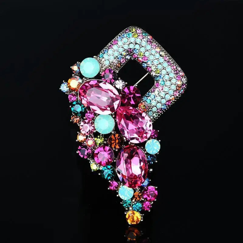 A vibrant crystal flower brooch pin for women featuring a square-shaped design adorned with dazzling pink and turquoise rhinestones set in an intricate metal frame.