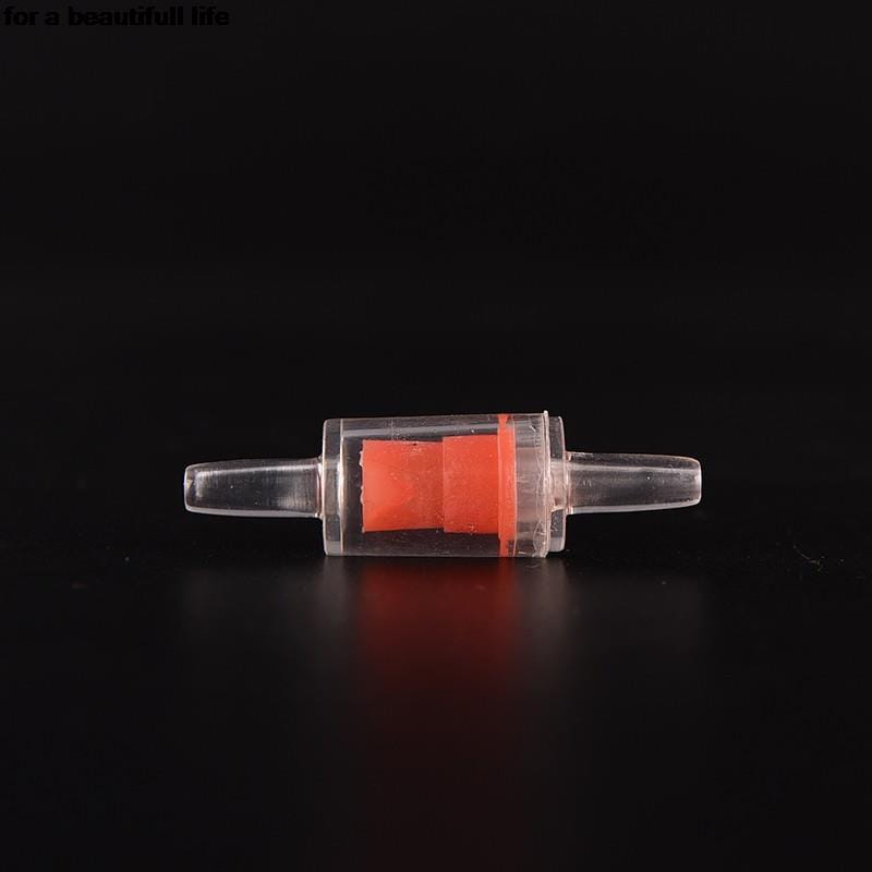 Válvula de retención de plástico transparente para bomba de aire de acuario con un elemento interno naranja brillante para un flujo de aire unidireccional.
