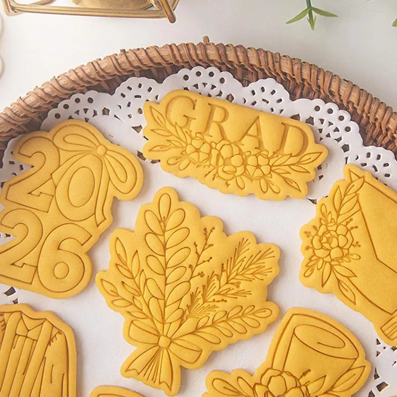 yellow plastic 2026 graduation cookie cutter set featuring intricate floral and academic designs for themed baking.