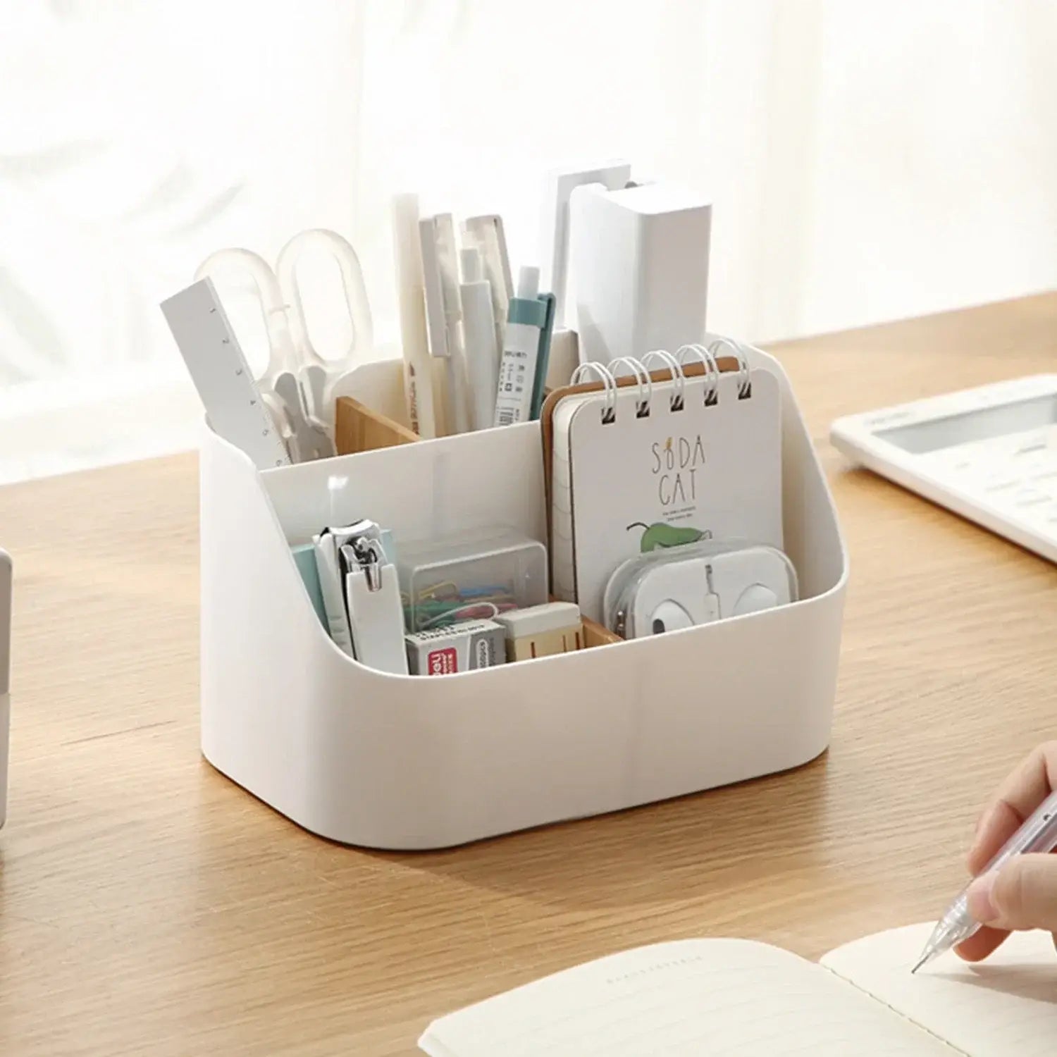 White plastic desk organizer and makeup brush holder with multiple compartments holding pens scissors and stationery items.