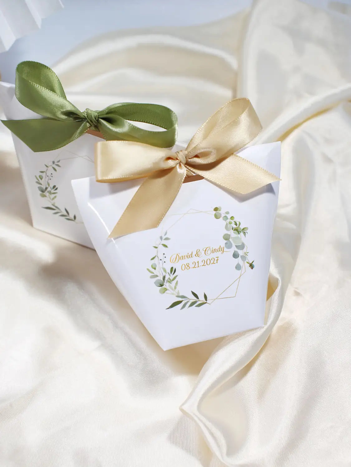Boîte à faveur de mariage en papier blanc avec un motif de couronne de feuilles vert et or, nouée avec des nœuds en satin vert olive et doré champagne, boîtes à faveur de mariage florales personnalisables, 50 pièces.