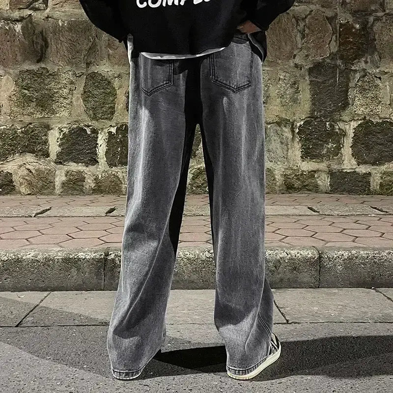 Jeans à jambes larges pour hommes en denim style streetwear coréen, présentés depuis l’arrière : tissu denim gris avec une finition délavée usée et des poches arrière classiques.