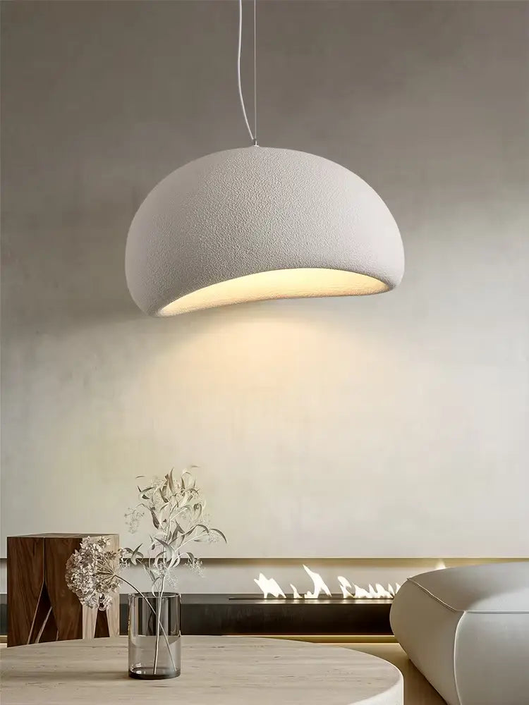 Una luminaria colgante moderna blanca con forma de cúpula y pantalla con textura, con brillo interior cálido, adecuada para luminarias colgantes de sala y comedor.