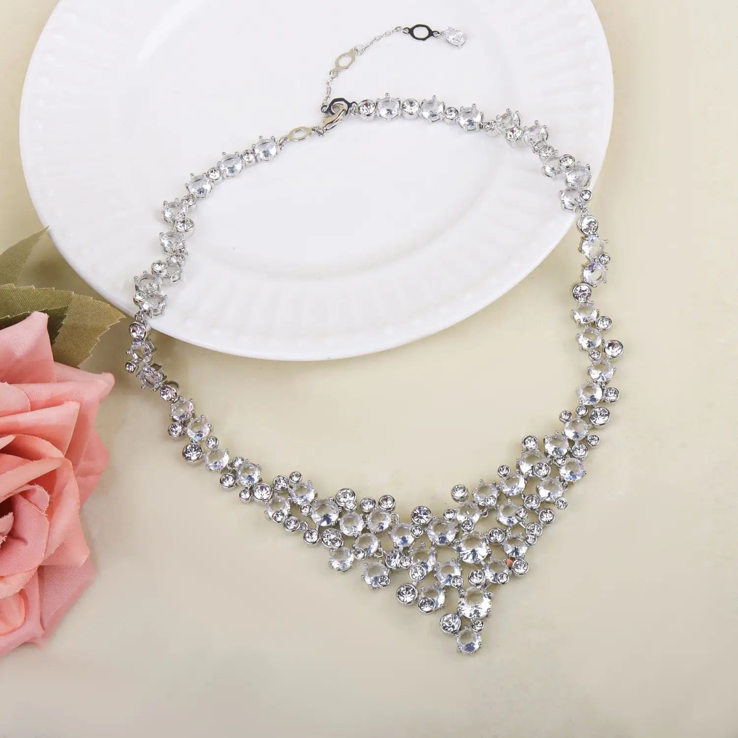 Un collier de l’ensemble de bijoux de mariage en cristal argenté, éclatant, orné de cristaux facettés transparents disposés dans un design en forme de V en cascade.