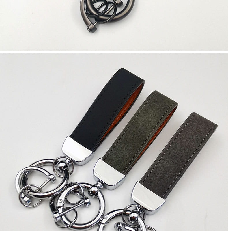 Three genuine leather keychains featuring black, olive green, and dark gray leather straps with contrasting stitching and polished chrome metal rings for car keys.