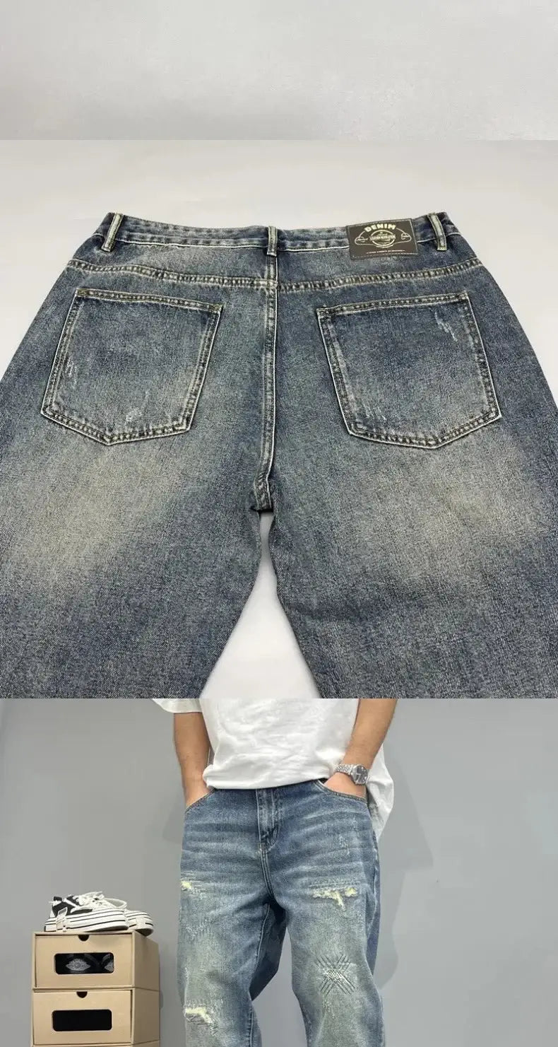 ブルーの、男性用のルーズフィット、ダメージ加工のストレートレッグデニムジーンズ（色あせた風合いとダメージ加工のディテール）。