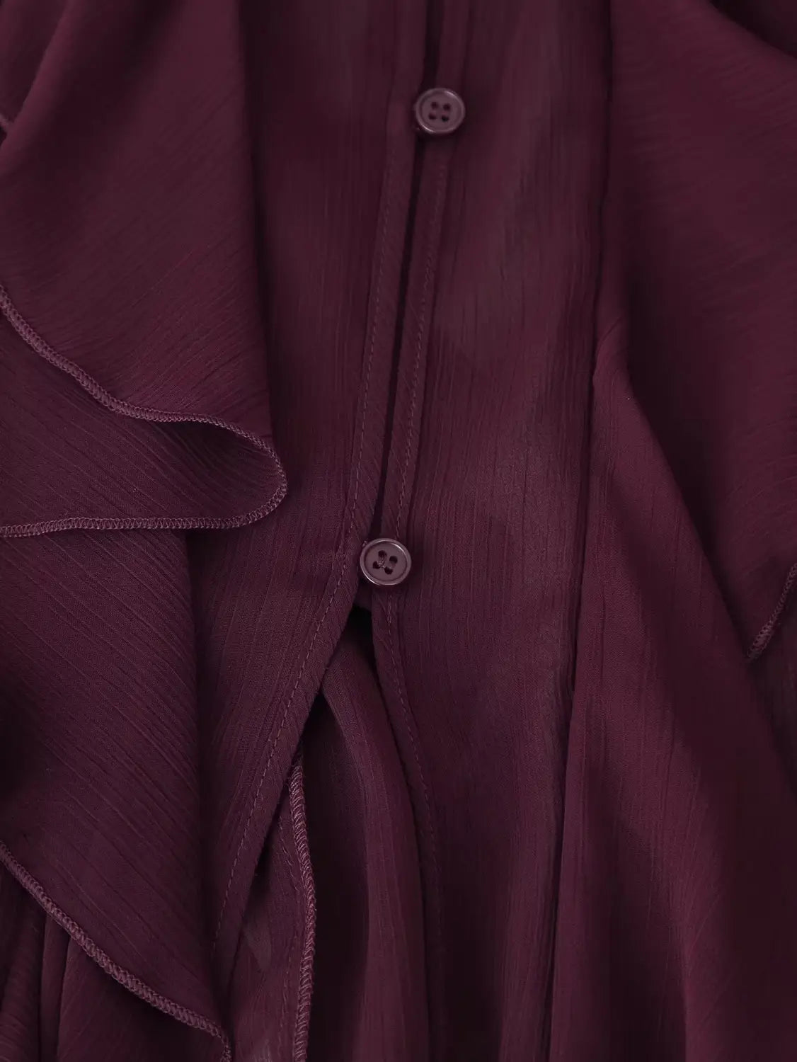 A deep burgundy long sleeve ruffle shirt long chiffon blouse with delicate ruffled detailing along the front placket and matching dark buttons.