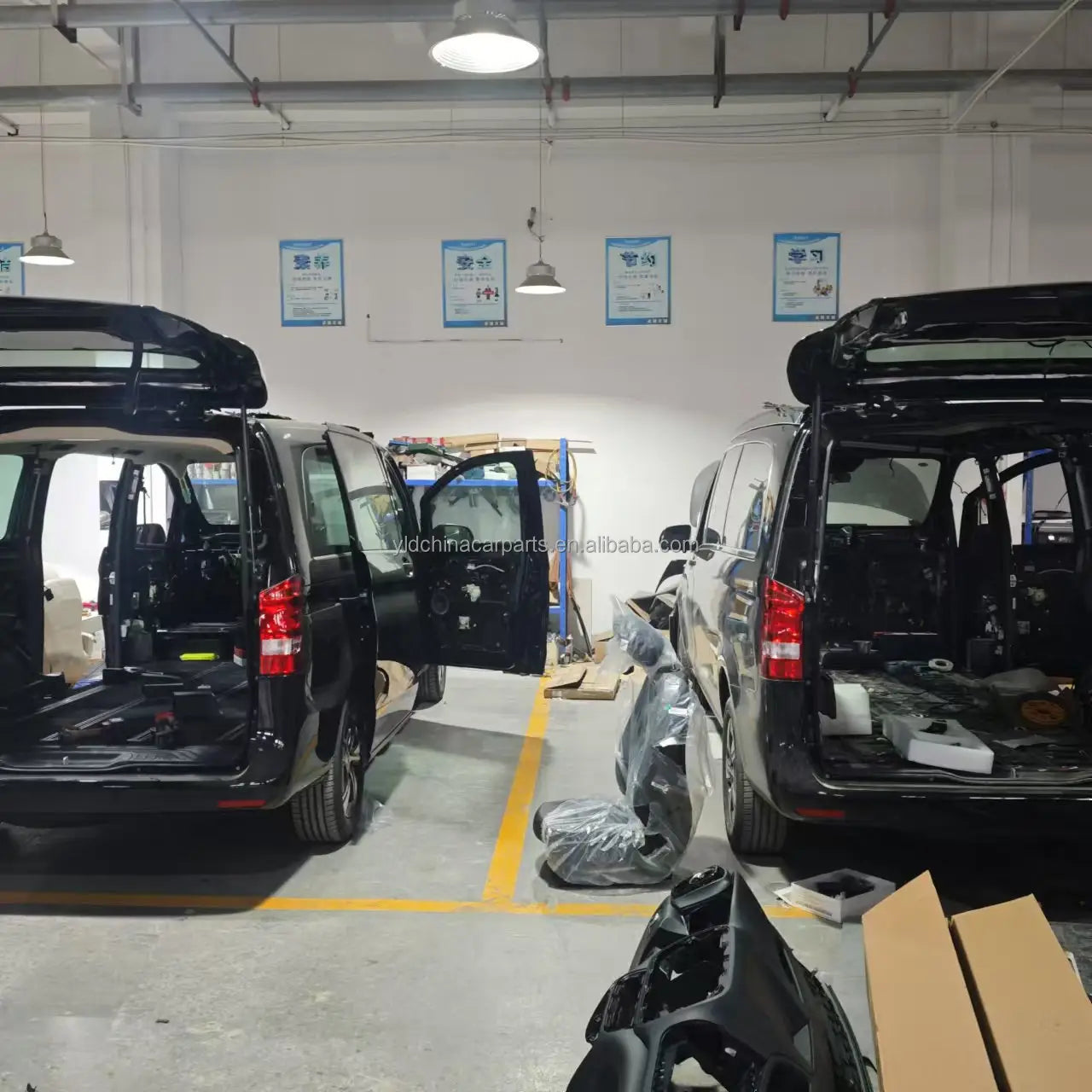 black Volkswagen Transporter van with open doors and rear hatch in workshop showcasing the universal RV swivel seat base and slide rail product.