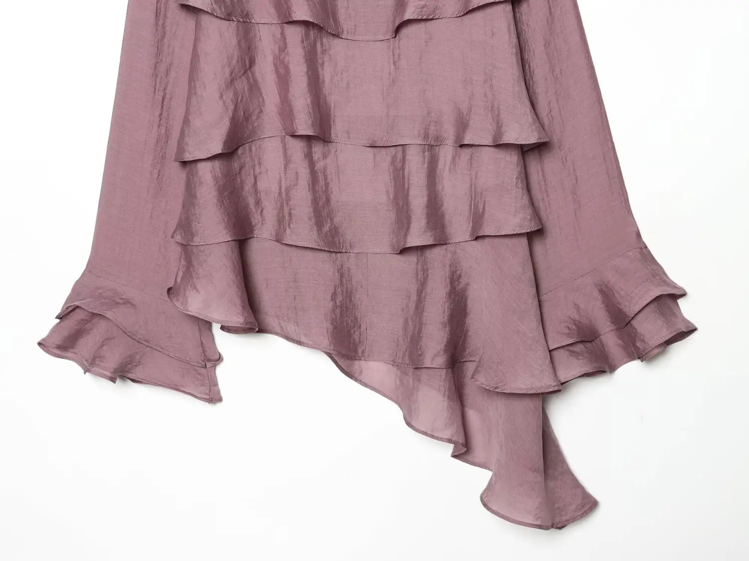 A flowing mauve ruffled skirt with layered cascading tiers made of lightweight semi sheer fabric paired with a brown chiffon flare sleeve blouse highlighting the sleeve style.