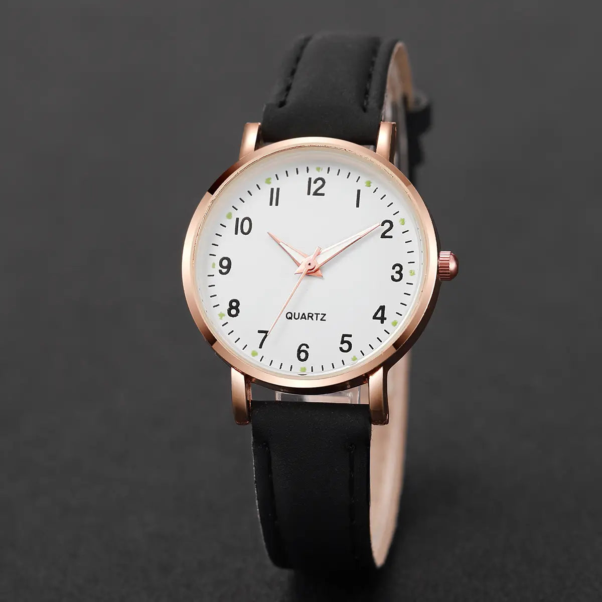 Arabic dial rose gold leather women watch featuring a rose gold-toned quartz case with a white dial, minimalist hour markers, and a black leather strap.