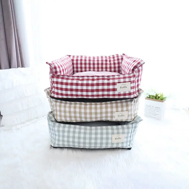 Stacked plush gingham check pet beds in red and white beige and gray cotton designed as comfortable dog sofas.