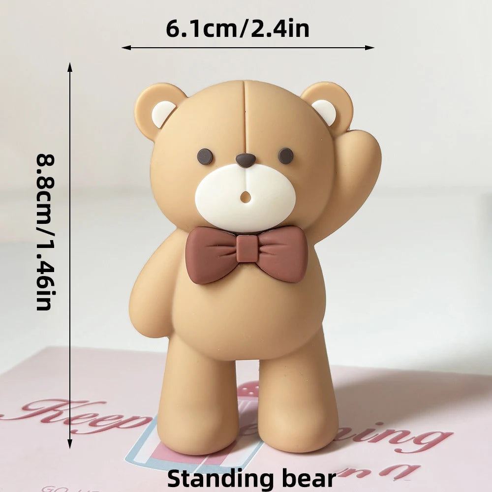 ミニベア ケーキトッパーセットの一部として、白い鼻先、黒い目、鼻、茶色の蝶ネクタイを備えた可愛らしいタン色のベアの置物です。
