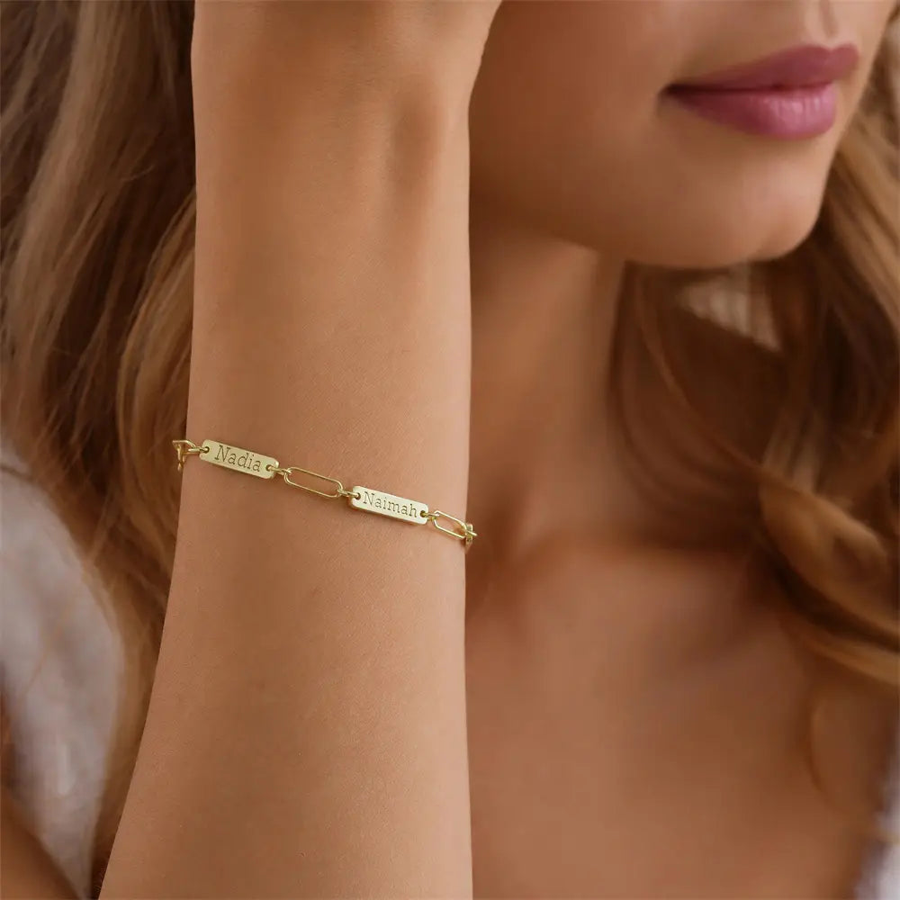 Armband mit goldfarbenem Kettenzubehör mit zwei rechteckigen gravierten Namensplaketten „nadia“ und „naïmah“, individuell graviertes Lederarmband mit Namensanhänger für Herren.
