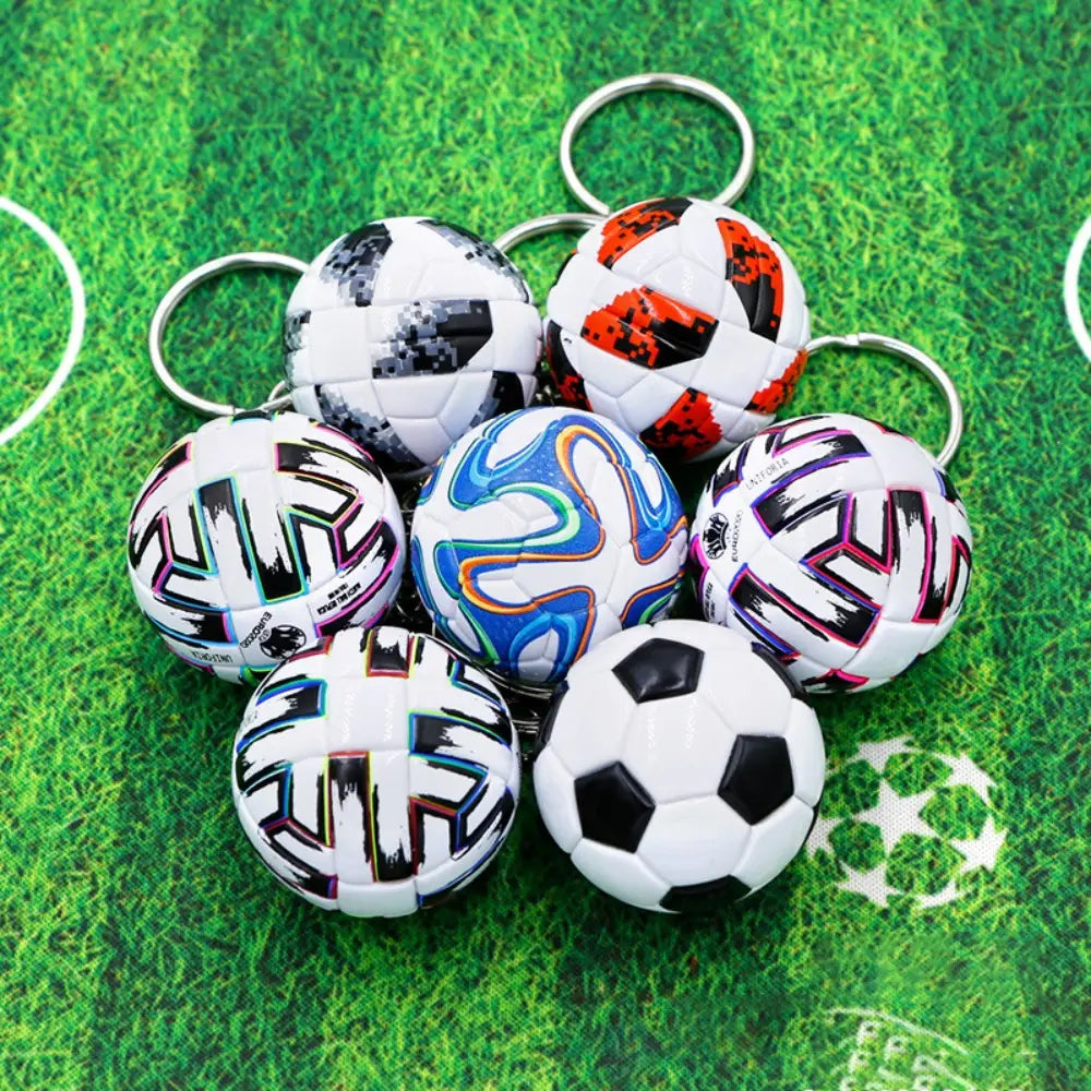 A collection of leather football keychain sports souvenirs featuring miniature soccer ball designs in vibrant and classic black and white patterns with metallic rings for attachment.