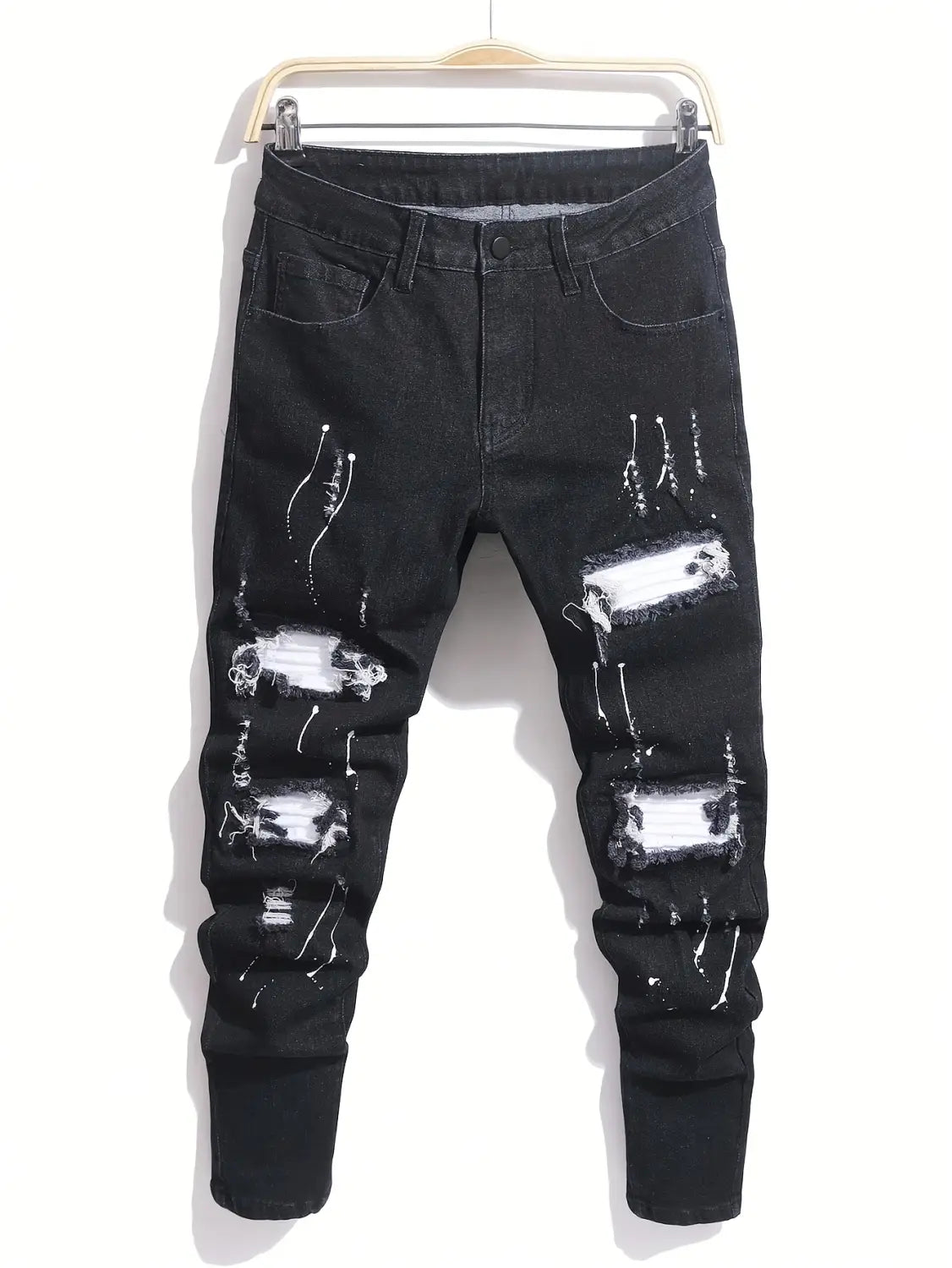 Herren-Ripped-Skinny-Bikerjeans in schwarzem abgetragenem Denim mit weißem Farbspritzer-Design und zerrissenen Patches für den Streetwear-Stil.