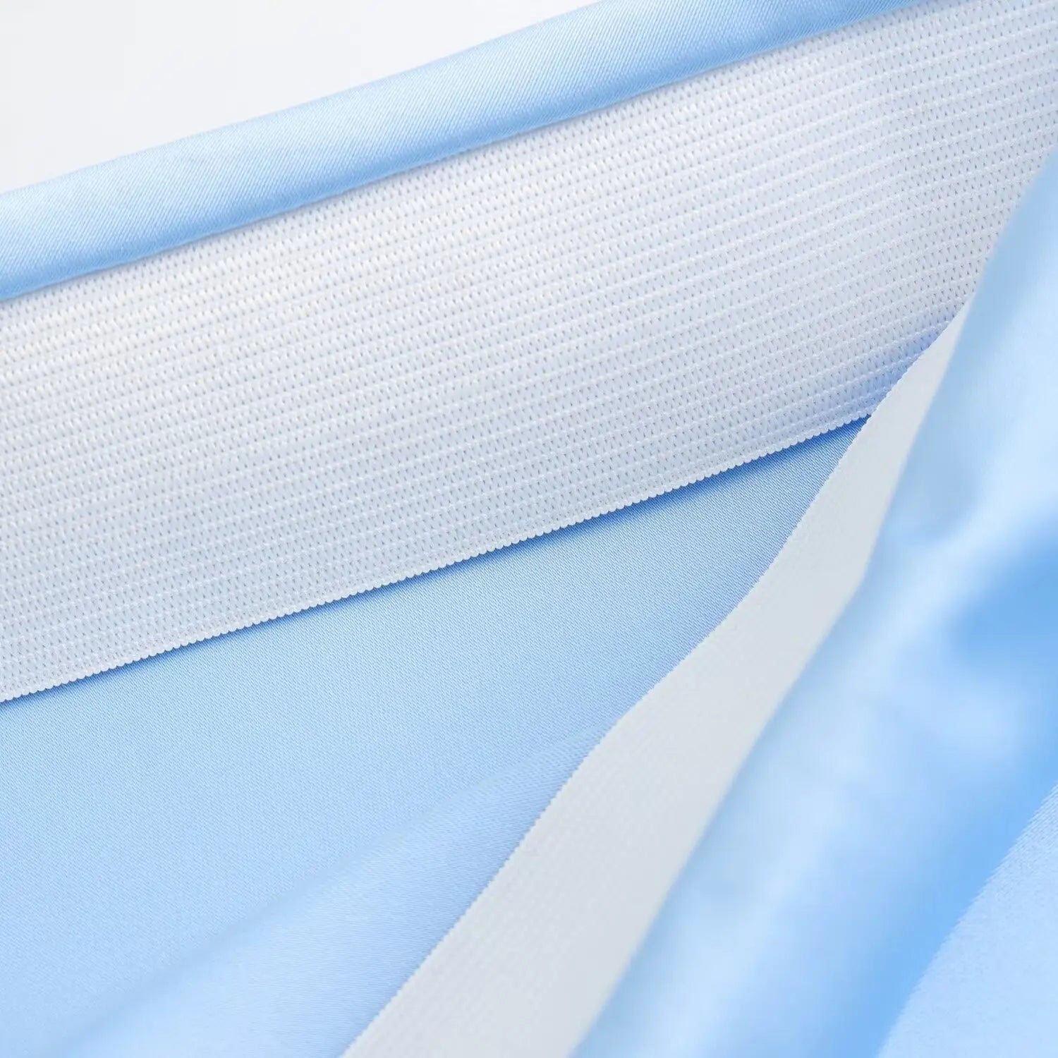 Bandes de tissu tissé bleu clair et blanc, motif côtelé texturé sur une jupe midi en satin à taille haute et design long élégant.