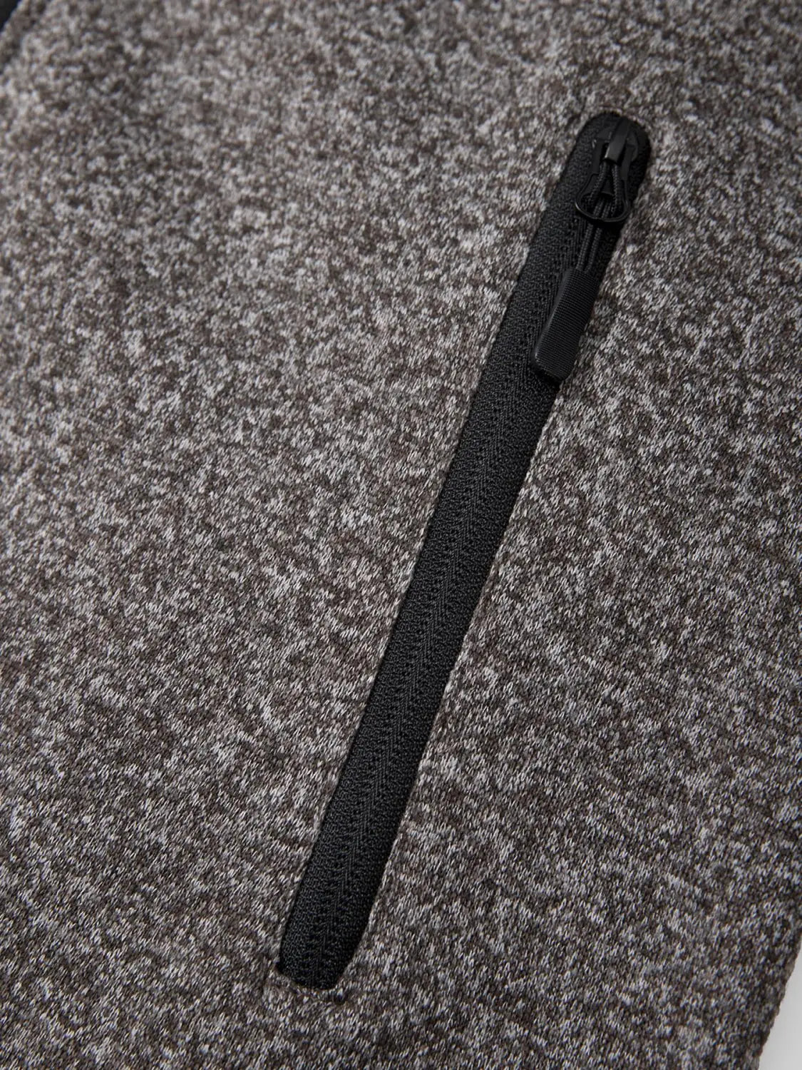 Black zipper with textured pull tab on men’s fleece lined knit hooded jacket in heather gray flecked fabric