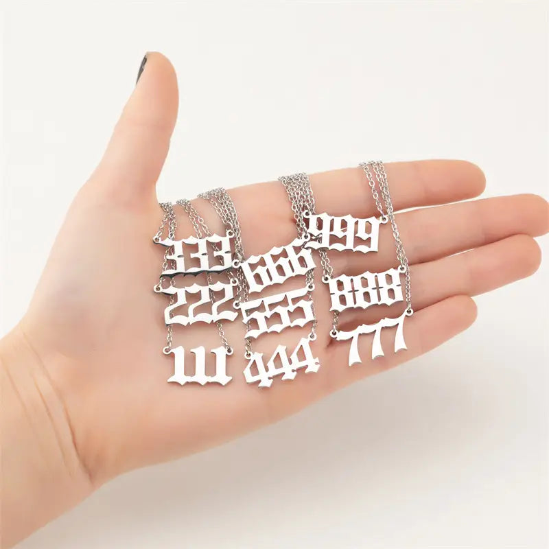 silver-toned necklace pendants featuring bold gothic-style repeating digit numerals 333 and 888 in the gold angel number 7 necklace collection