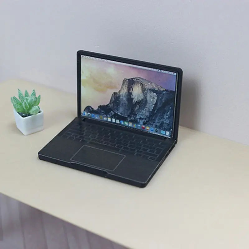 Schwarzes Mini-Laptop-Puppenhauszubehör mit matter Oberfläche und geöffnetem Bildschirm, der das Yosemite-Nationalpark-Wallpaper aus Legierung zeigt.