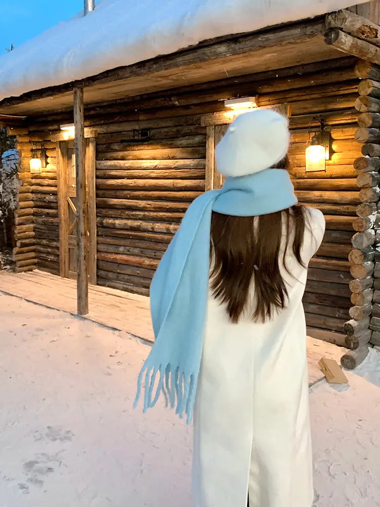 Una bufanda de cachemir azul claro suave con extremos con flecos, llevada alrededor del cuello como una bufanda de cachemir de invierno rosa para mujer.