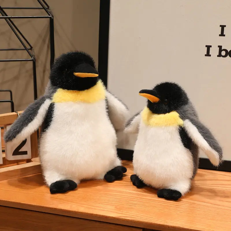 Two plush penguin stuffed animal soft toy pair with black heads yellow neck bands white bellies and gray wings.