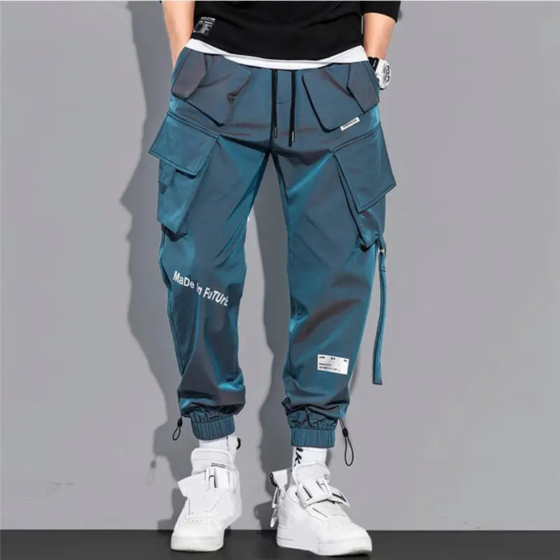 Teal mens tactical cargo pants in durable fabric with multiple pockets and a drawstring waistband designed for streetwear.