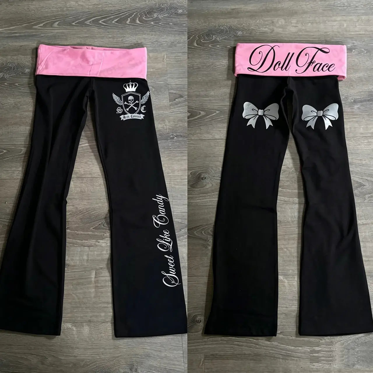 mallas acampanadas negras con una banda elástica rosa que presenta un lazo gráfico con diseño contrastante en blanco y plateado y elementos de texto en estilo y2k gótico.