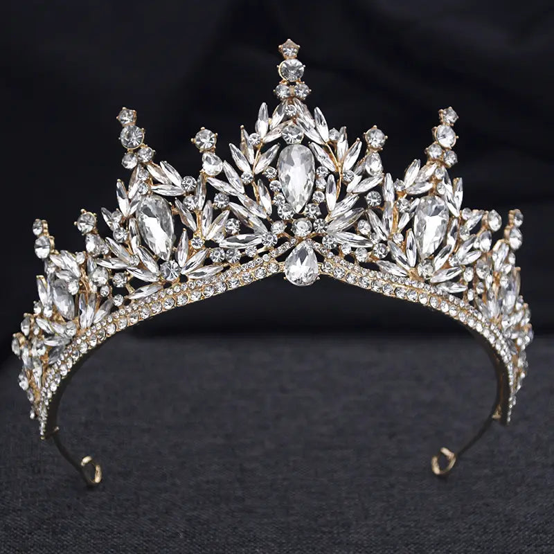 Une couronne de mariée étincelante en tons or, ornée d’accents en cristal transparents en forme de goutte et de feuilles pour des accessoires de mariage.
