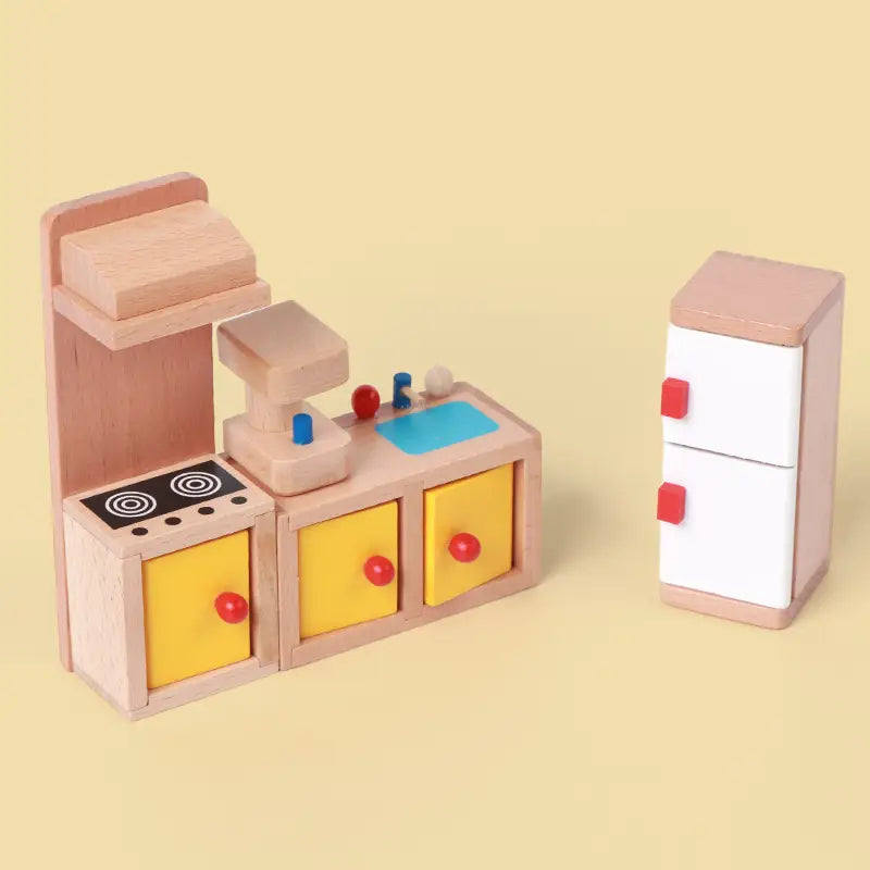 Holz-Puppenhaus-Möbelset mit einer Spielküche mit Schränken aus hellem Holz, gelben Schubladen mit roten Knöpfen sowie einem weißen Kühlschrank mit rosa Zierleiste und roten Griffen.