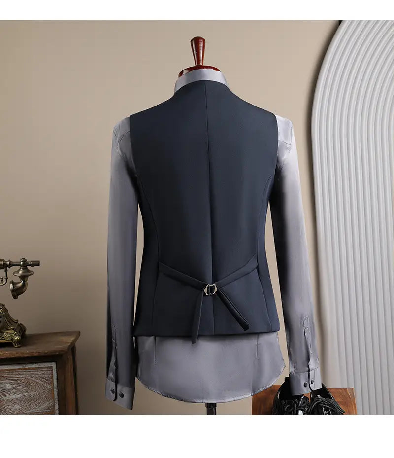 Gilet bleu marine confectionné avec manches longues gris clair contrastantes et boucle à tonalité argentée à l’arrière, dans l’ensemble costume d’affaires pour homme slim fit en trois pièces, adapté à la mode masculine, aux affaires et aux soirées décontractées.