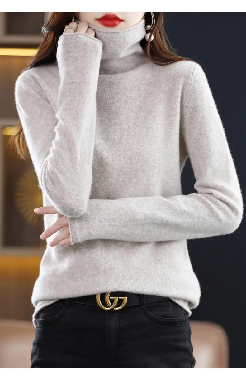 A soft light gray merino wool turtleneck sweater for women featuring a cozy textured knit and long sleeves.
