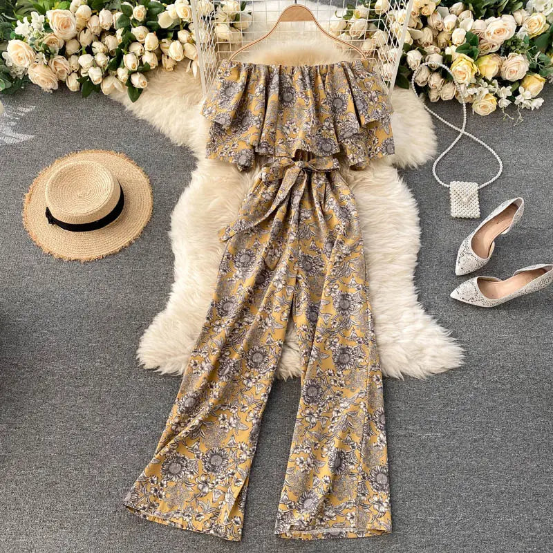 Enterizo de pierna ancha con estampado floral amarillo y escote tipo bardot, mangas con volante y cinturilla atada, adecuado para ocasiones casuales o semiformales