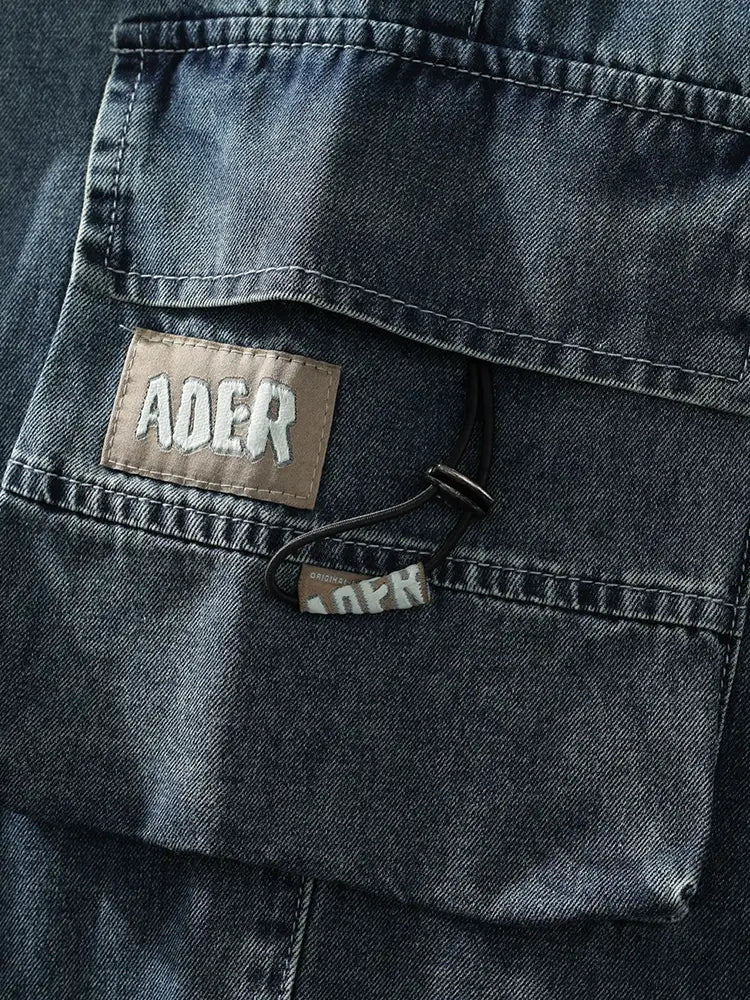 Jean cargo en denim ample pour homme, grande taille, fabriqué dans un denim teinte foncée : patch en cuir marron avec branding brodé blanc au dos.