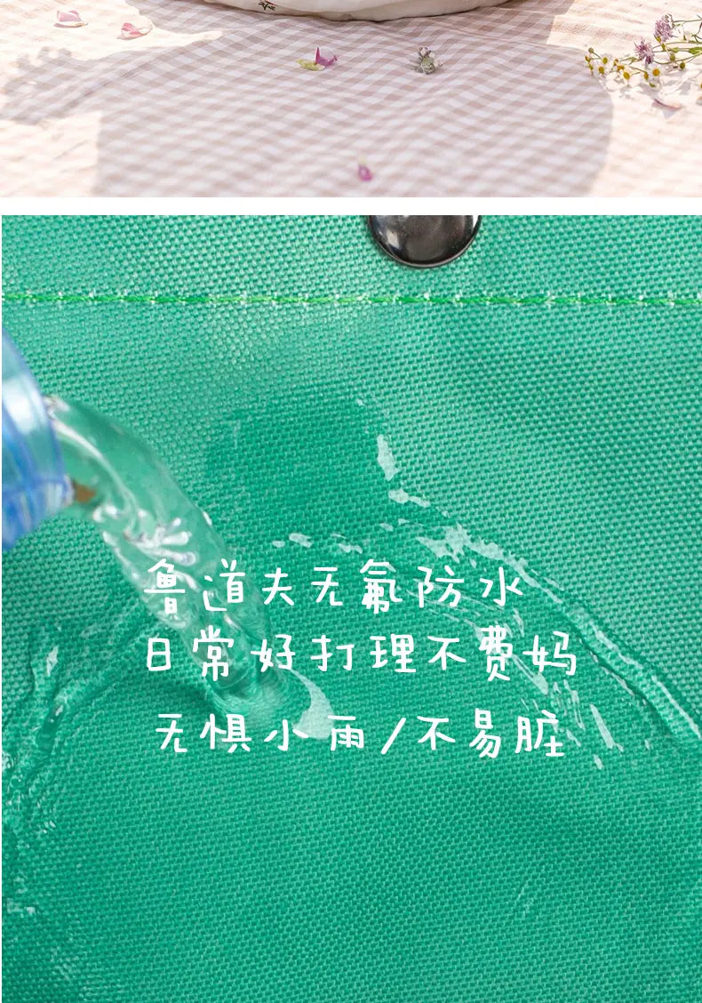 Grüne wasserfeste Tragetasche aus Stoff mit schwarzem Metall-Schnappverschluss, als Teil eines leichten Fuzzy-Kinderrucksacks für den Kindergartentagesgebrauch.