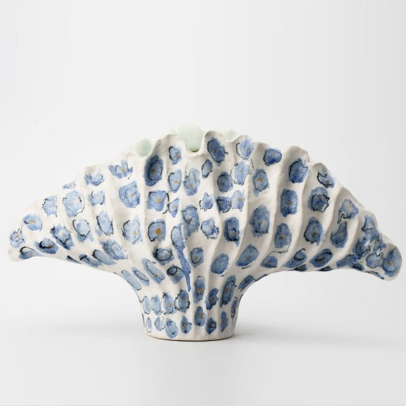 Un vase à fleurs en céramique blanc, à la forme d’éventail festonnée et orné de motifs floraux bleus peints à la main, en format 37 x 12 x 23 cm, pour une poterie décorative moderne et des effets d’exposition.
