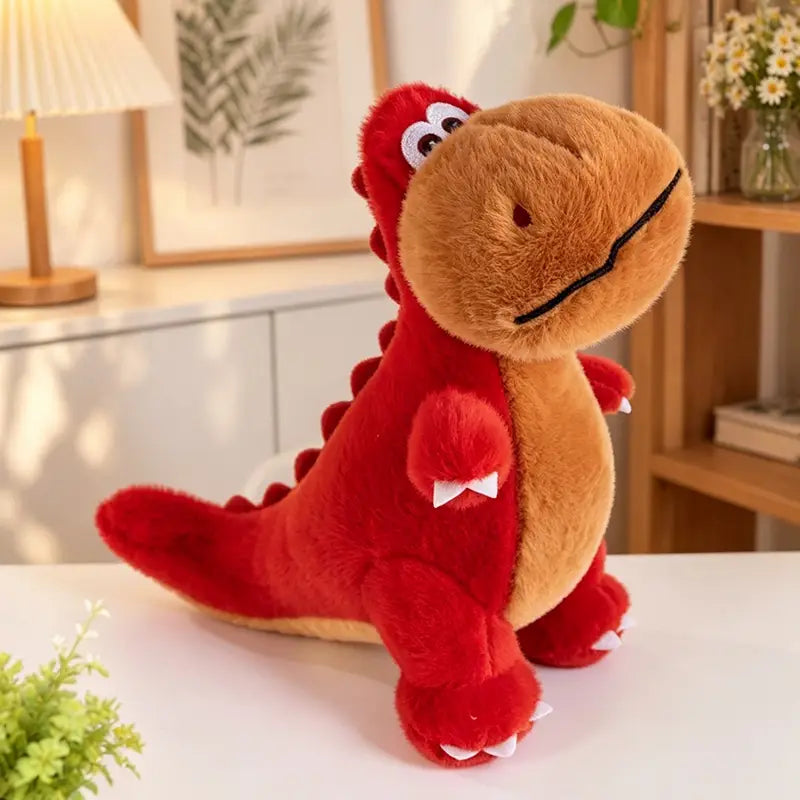 Un jouet peluche de dinosaure coloré présentant un animal en peluche doux rouge et beige, avec des yeux brodés blancs, un sourire cousu en noir, de petites griffes blanches sur ses pattes, et de minuscules piquants blancs le long de son dos.