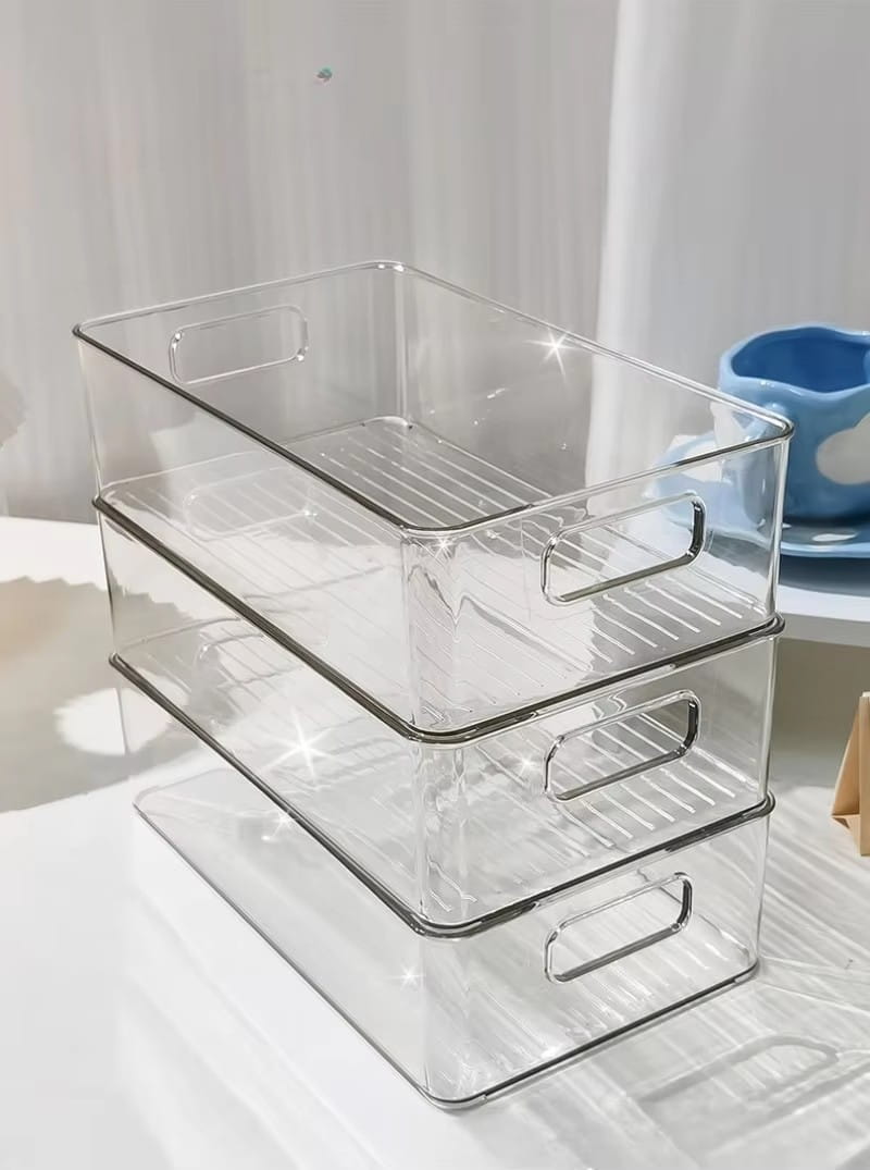 Conjunto apilable de organizadores de maquillaje de plástico transparente y recipientes de almacenamiento para cajones, con construcción transparente, asas en tono plateado e interiores acanalados.