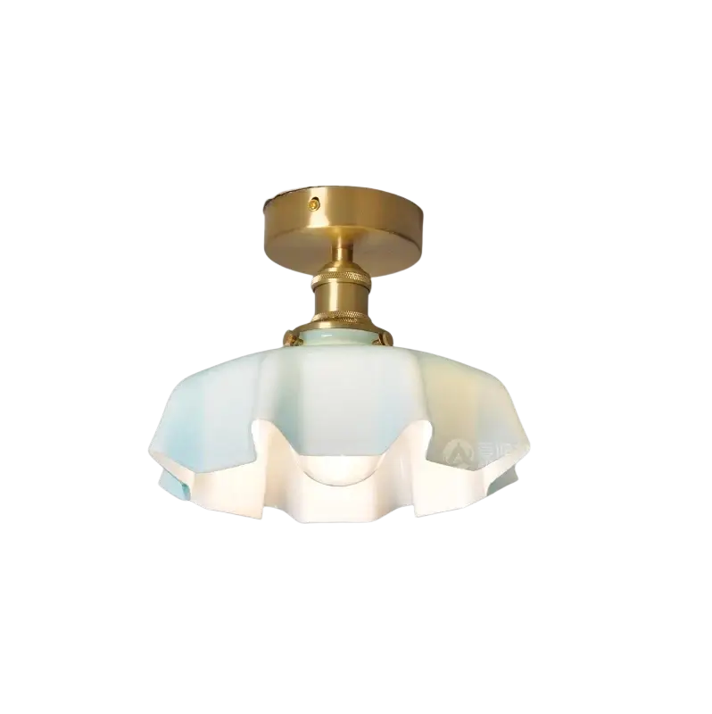 Un luminaire de plafond de style vintage avec une base en métal à finition laiton, un abat-jour à jupe florale en verre opalescent dans des tons bleu et blanc doux, et une tête de lampe en cuivre.