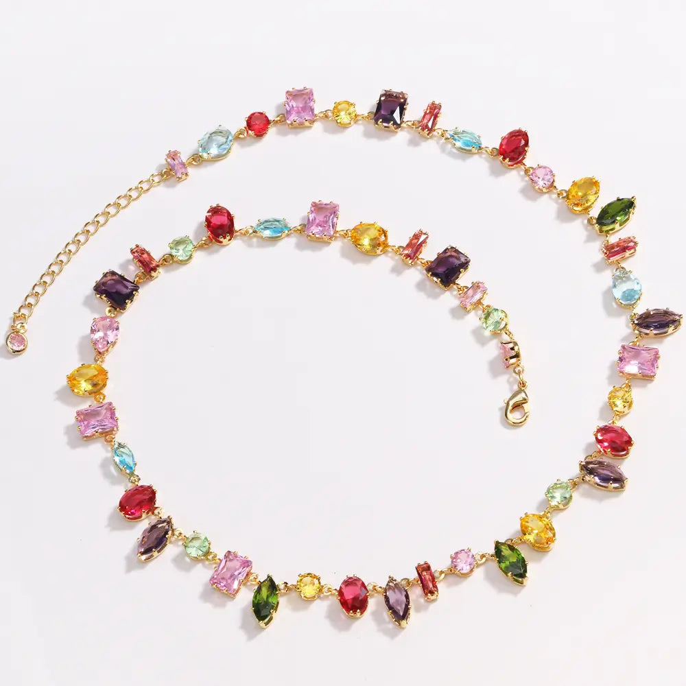 A colorful zircon crystal gold plated necklace featuring a vibrant gold tone and a dazzling array of multicolored gemstones in various cuts and shapes.